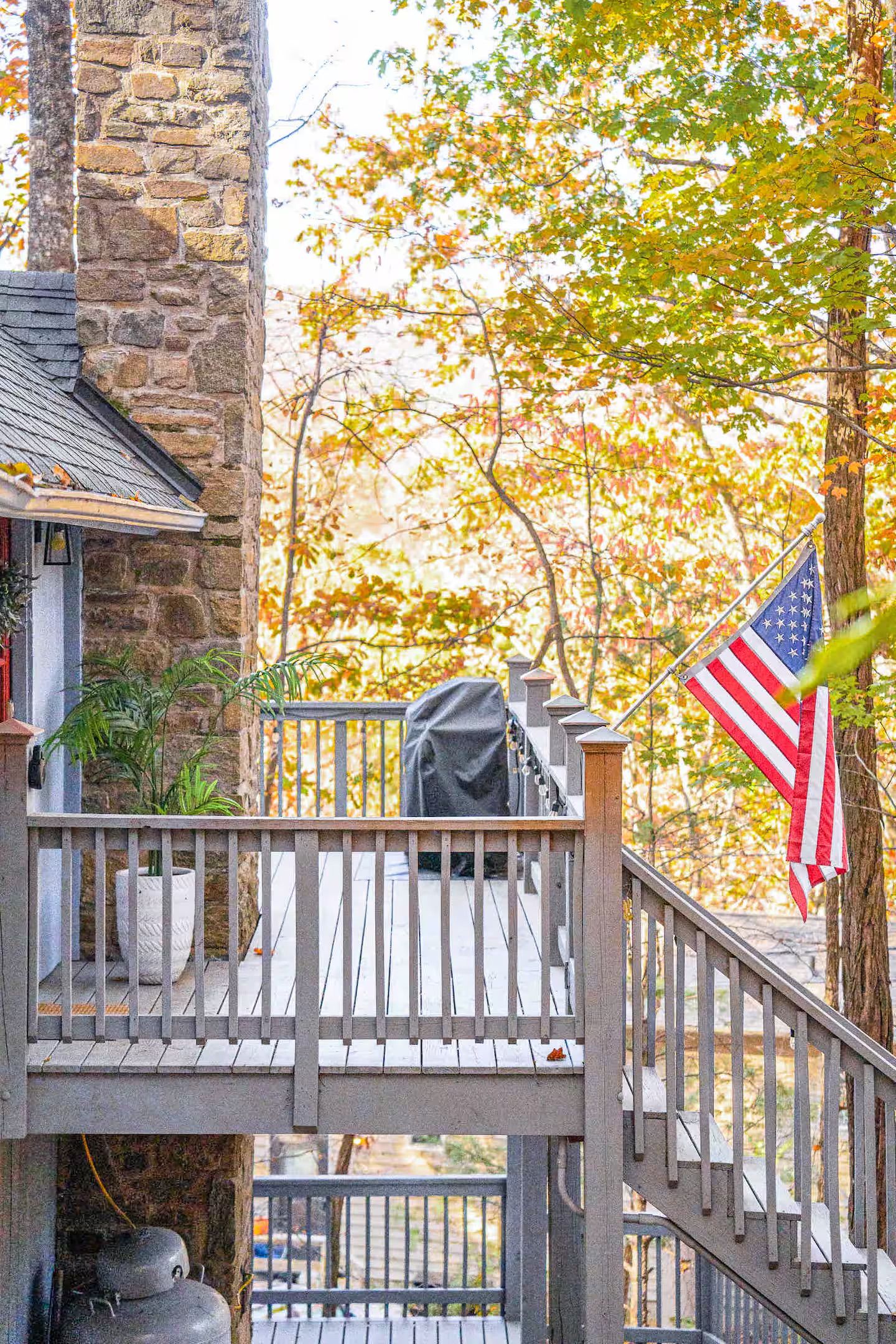 A stone building with a wooden deck and an American flag.