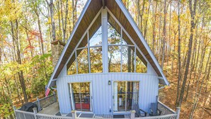 A cabin with a balcony, a hot tub, and a deck.