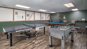 Une pièce équipée d’une table de ping-pong, d’un baby-foot et d’une table de billard.