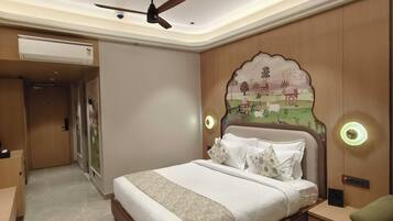 A hotel room with a bed, a flat-screen TV, a ceiling fan, and a decorative wall mural.