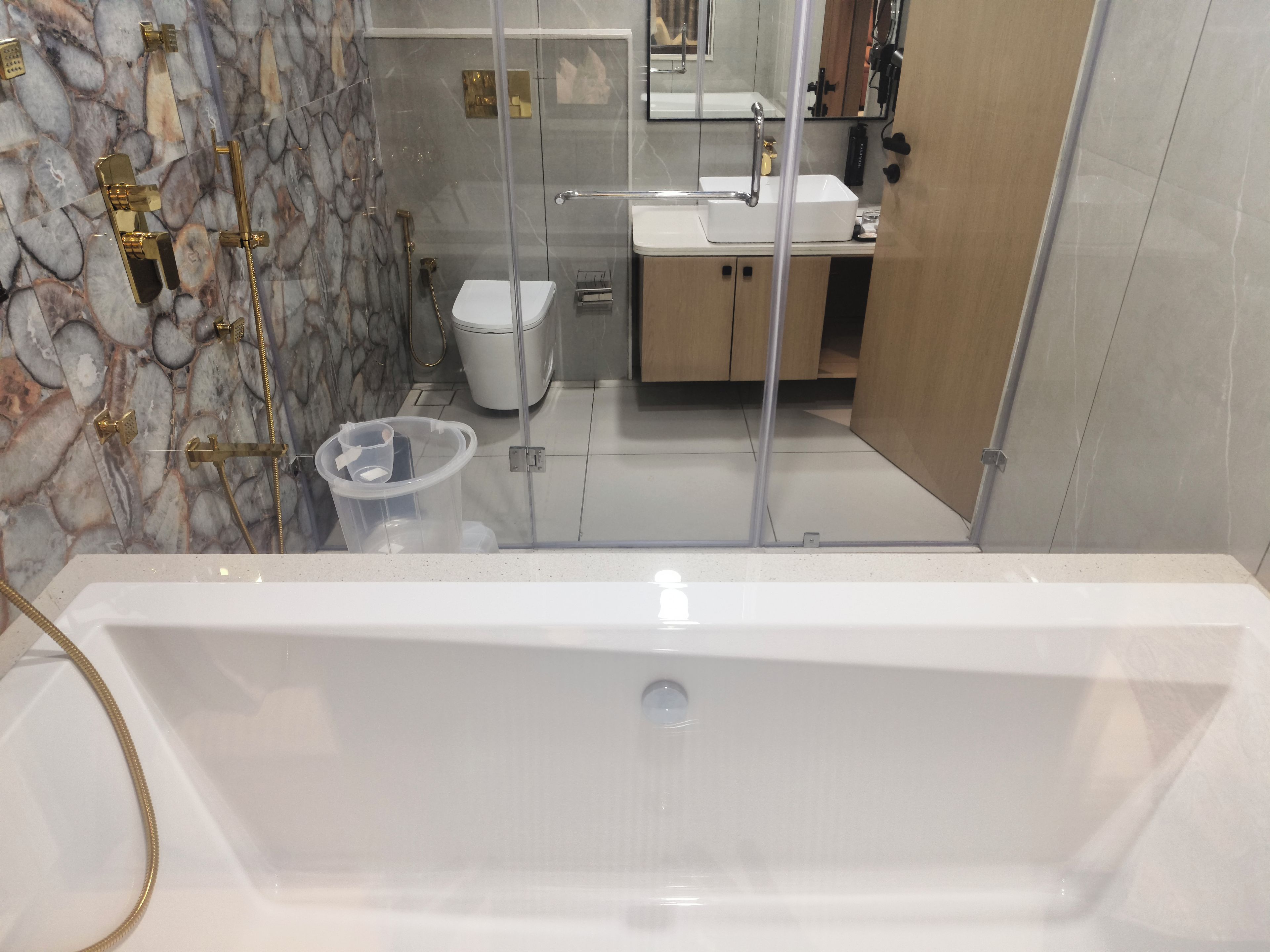A bathroom with a bathtub, a toilet, and a shower area.
