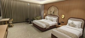Una habitación de hotel con dos camas, un escritorio y una silla.