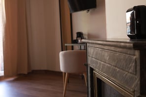A room with a wooden cabinet, a television mounted on the wall, and a chair.