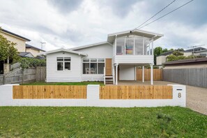 A modern two-story house with a large balcony, a fenced yard, and a number '8' sign. - Hamptons on Heales Classic Beach House Charm (Dromana)