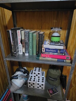 Una estanteria amb diversos llibres i una cuina de campanya.