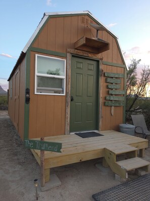 A wooden cabin with a green door, a window, and a wooden deck with steps leading to the door. - Adventure by day, Stargazing by night , unplug under the Big Bend Stars
 (Terlingua)