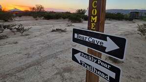 Un panneau indicateur en bois, orné de la silhouette d’un ours et d’une inscription « Bienvenue », indiquant la direction des sentiers.