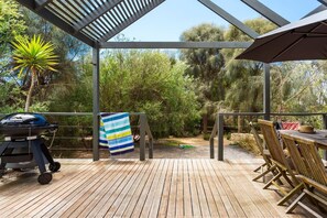 An outdoor patio with a grill, a striped towel, wooden chairs, and a table. - Stroll to the Sea Sun drenched Seaside Lifestyle (Rye)