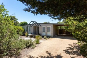 A single-story house with a covered porch, a front yard, and a driveway. - Stroll to the Sea Sun drenched Seaside Lifestyle (Rye)