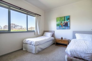 A bedroom with two beds, a window with curtains, a painting on the wall, and a nightstand with a cup. - Viewbank Homestead A Sprawling Garden Estate (Shoreham)