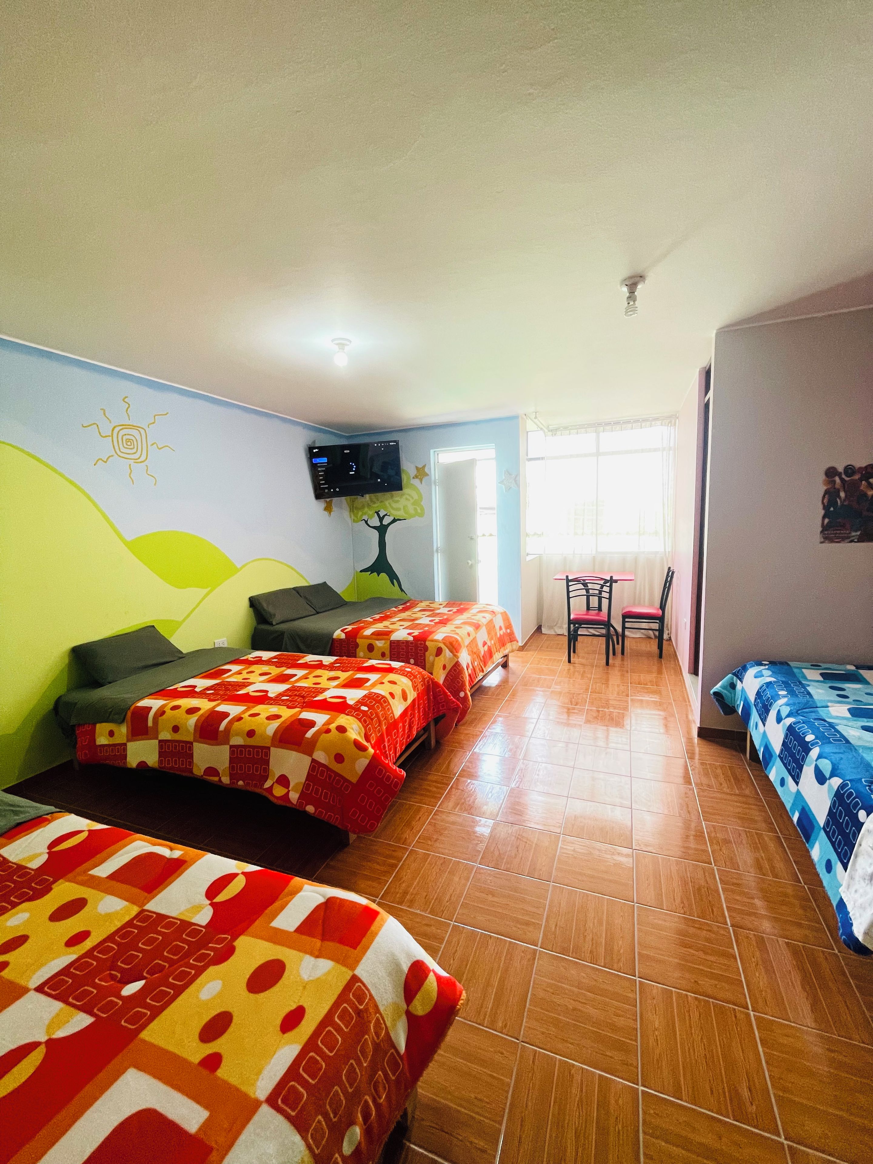 A hotel room with two beds, a TV, a desk, and a chair.
