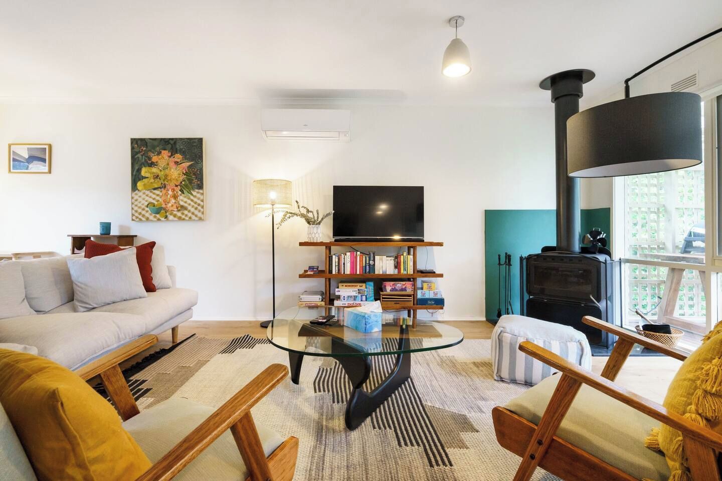 Un salon moderne avec un canapé, une table basse, une bibliothèque et une cheminée.