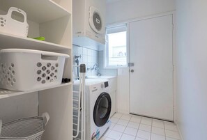 A full laundry setup ensures convenience for longer stays, with a washer, dryer, storage and a private rear entrance. - Moonah Retreat—Coastal Serenity near Hot Springs (Sorrento)