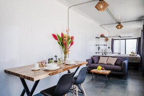 A modern living space with a dining area, a sofa, and a coffee table.