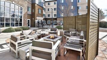 An outdoor seating area with multiple lounge chairs and a fire pit.