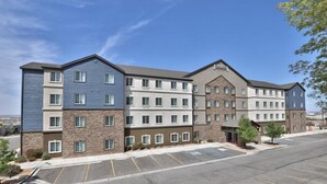 A multi-story hotel with a parking lot in front. - 2BR Accessible Suite | Free Hot Breakfast + Pool (Albuquerque)