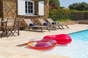 Area piscina con lettini e un galleggiante gonfiabile.