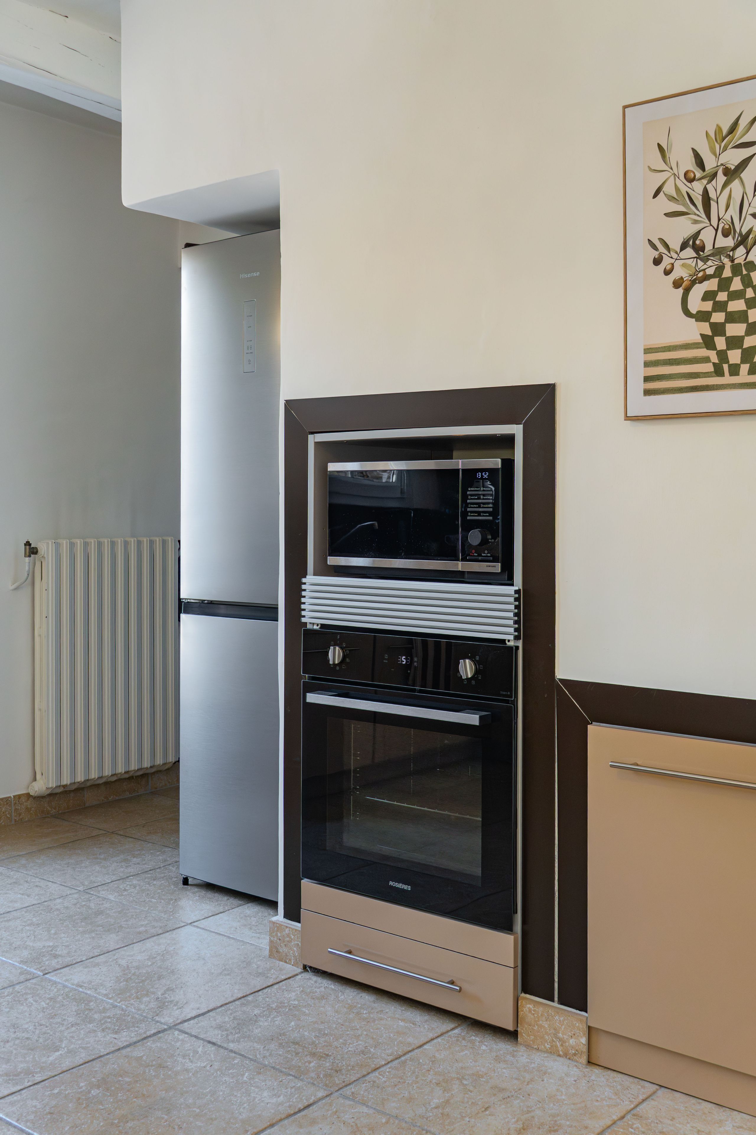 Une cuisine compacte équipée d’un four encastré, d’un réfrigérateur et d’un four à micro-ondes.