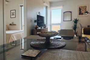 Una sala moderna con una mesa de centro de vidrio, un televisor y un sofá.