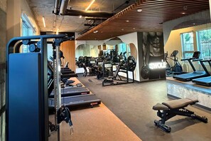 Een fitnessruimte met trainingsapparatuur, loopbanden en krachtapparaten.