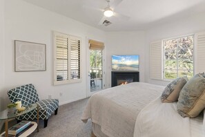 A bedroom with a bed, a fireplace, a television, and a view of the outdoors. - Spanish Hacienda w/ Breathtaking Mountain Views! (La Quinta)