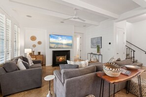 A living room with a fireplace, sofas, a coffee table, and a TV. - Spanish Hacienda w/ Breathtaking Mountain Views! (La Quinta)