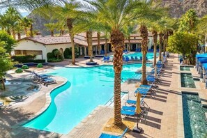 A pool area with lounge chairs and palm trees. - Spanish Hacienda w/ Breathtaking Mountain Views! (La Quinta)