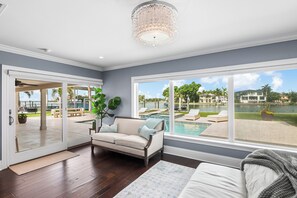 Un vaste salon avec vue sur une piscine et une terrasse.