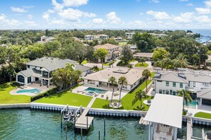 Un quartier résidentiel comprenant plusieurs maisons, une piscine et un quai avec des bateaux.