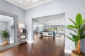 A spacious living area with hardwood flooring, a large mirror, a lamp, and a potted plant. - WATERFRONT OASIS-4 BED/3 BATH HOME WITH POOL, SPA, DOCKAGE CLOSE TO DOWNTOWN (St. Petersburg)