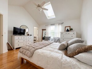 A bedroom with a bed, dresser, television, and a ceiling fan. - Welcome to your Cape Cod getaway! ONLY 1.5 miles to Menauhant Beach, this charmi (East Falmouth)