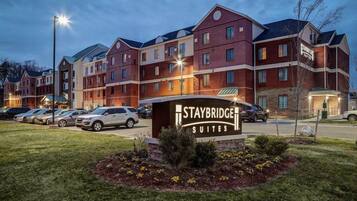 A Staybridge Suites hotel with multiple buildings, a parking lot, and a well-lit entrance.