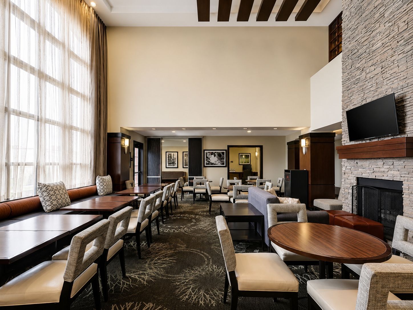Un hall de hotel con chimenea, zonas de estar y un televisor.