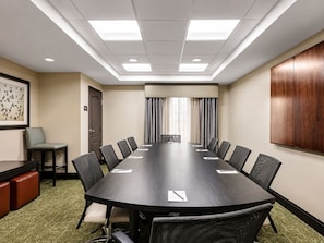 A conference room with a long table, chairs, a door, a framed picture, and a wooden cabinet. - ADA Studio Nr Washington D.C. | Free Breakfast! (Lanham)