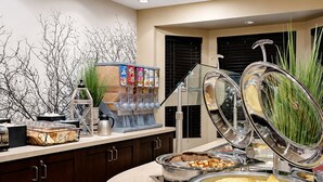 Un buffet proposant une variété de plats et une fontaine à boissons.