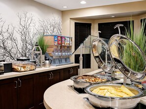 A buffet setup with various food items and a beverage dispenser. - ADA Studio Suite in Lanham w/ Tub | Free Breakfast (Lanham)