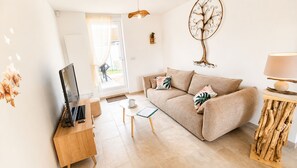 A modern living room with a sofa, coffee table, and a television. - The Béthune Zen House! Single-story house near shops and public transportation. (Béthune)