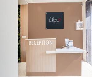 A reception desk with a sign above it that reads 'Collection' and a sign below that says 'RECEPTION'. - Classic Vidya Grand (Kichha)