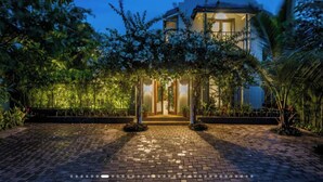 A house with a paved entrance, surrounded by greenery, and a clear sky. - French Villa with Private Pool (Awas)