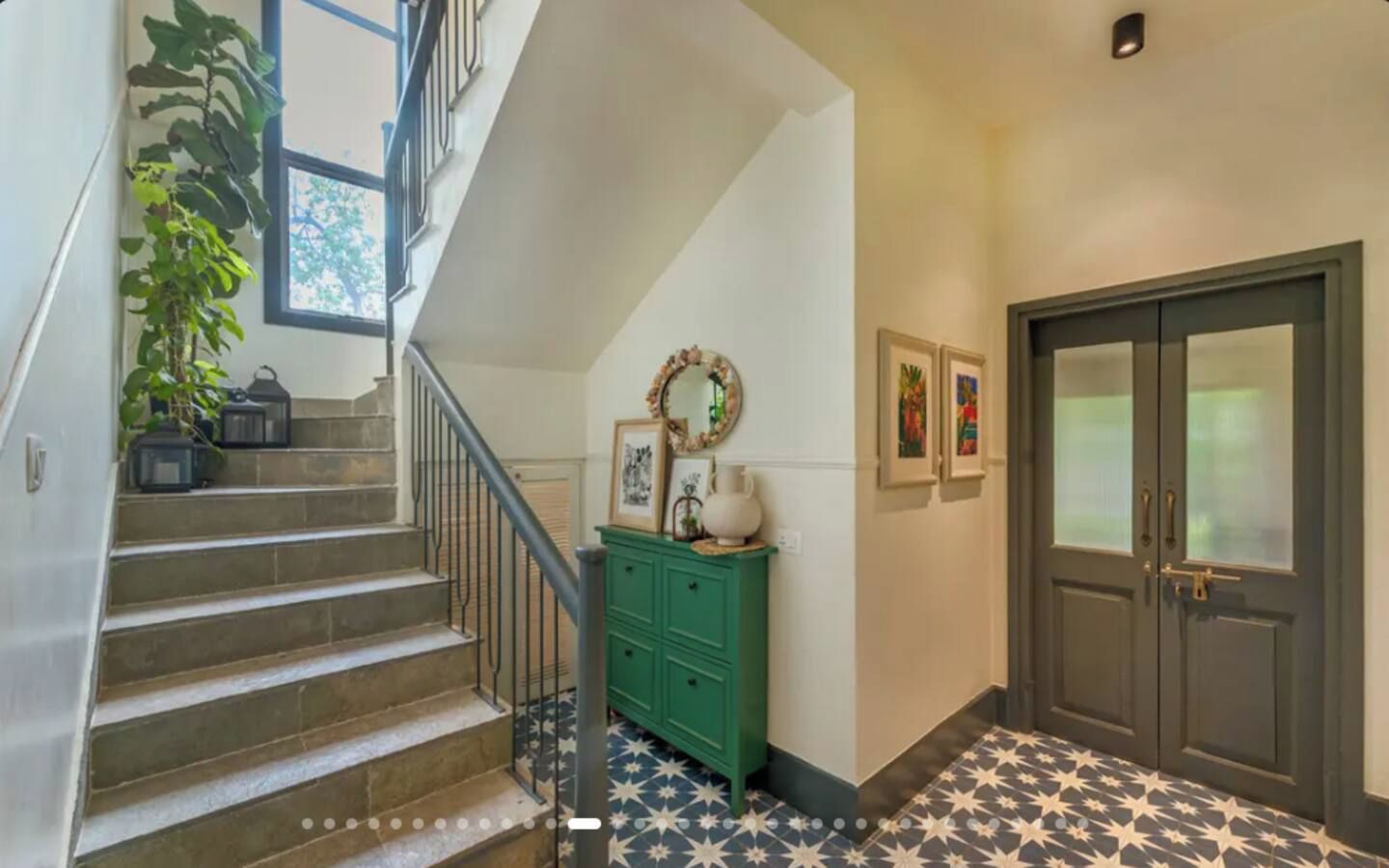 A staircase with a metal railing, a green cabinet, and a door with frosted glass panels.