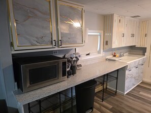 A kitchen with marble cabinets, a stainless steel microwave, a sink, and a countertop. - Stunning 2-bedroom Unit with in-unit Laundry in Desirable Downtown Manchester (Manchester)
