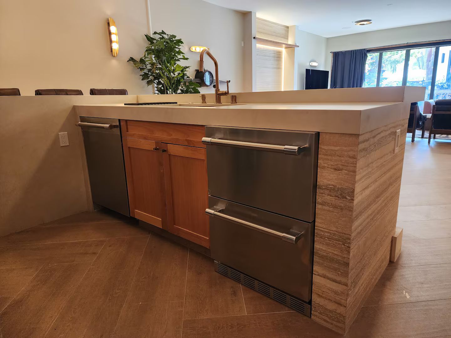 Une cuisine moderne dotée d’un lave-vaisselle encastré, d’appareils électroménagers en acier inoxydable et d’un meuble en bois.