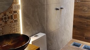 A modern bathroom with a toilet, bidet, and a large mirror. - SAMANA INN  (Arequipa)