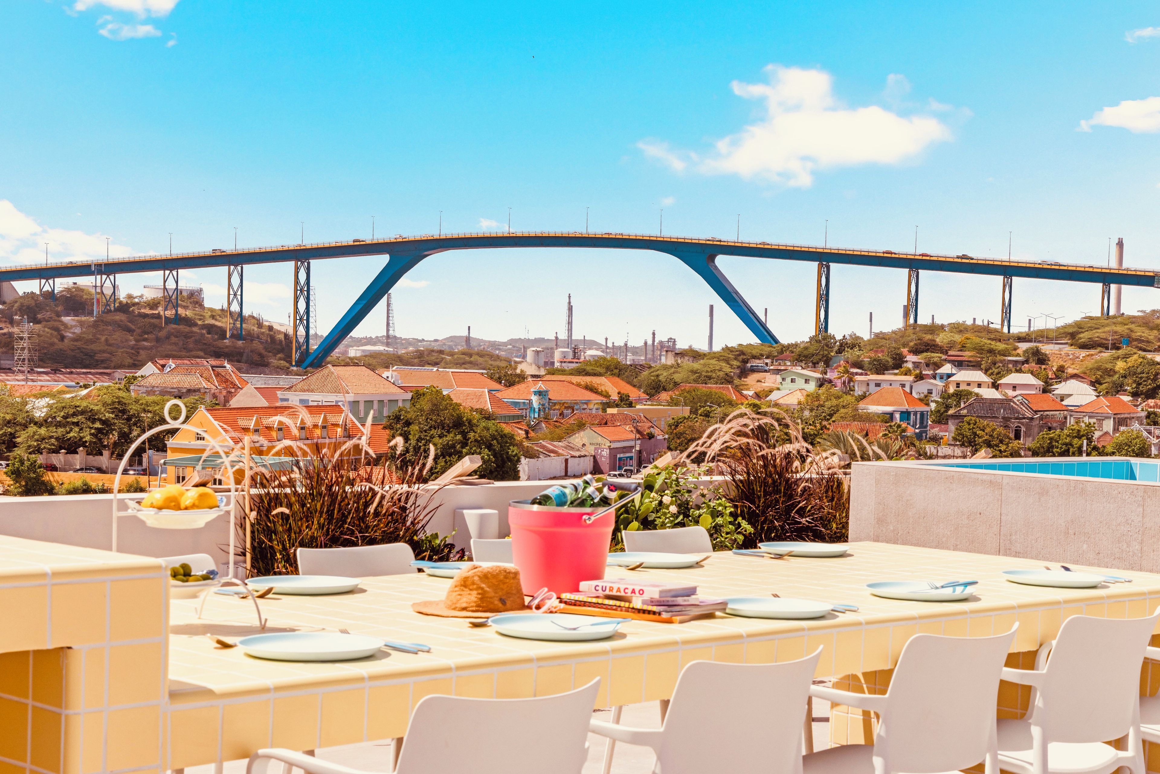 A dining area with a view of a bridge and industrial buildings.