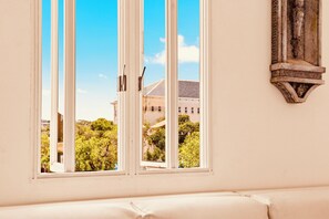 Ένα δωμάτιο με ένα μεγάλο παράθυρ ο, έναν λευκό τοίχο και μια διακοσμητική επένδυση από πέτρα στον τοίχο.