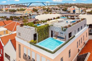 A rooftop pool with a view of the cityscape and a bridge in the background. - BIKINI (Willemstad)