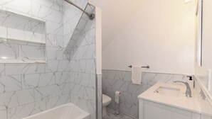 Een badkamer met een bad, toilet en wastafel.
