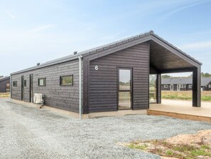 A modern building with a sloped roof, a large glass door, and a number '6' on the side. - 5 Star Holiday Home in Romo (Rømø)