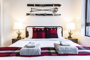 A bed with a plaid blanket, two pillows, and two lamps on either side. - Monashee Sunshine (Revelstoke)