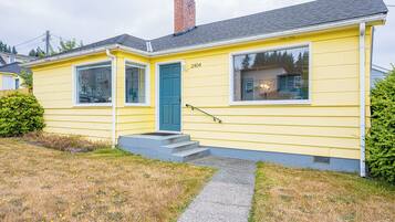 A yellow single-story house with a blue door, numbered 2404, and a small front porch.